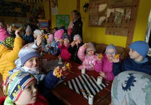 dzieci pokazują wykonane przez siebie świece z wosku pszczelego