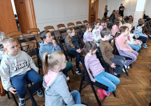 grupa dzieci siedzi na krzesełkach - publiczność
