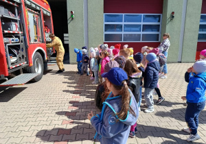 grupa dzieci ogląda pokaż sprzętu w wozie strażackim