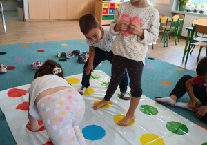 troje dzieci bawi się na twisterze