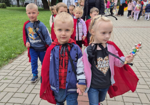 na pierwszym planie kilkoro dzieci przebranych za biedronki , na dalszym rówieśnicy ustawieni do zabawy w kole