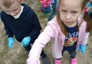 Dwie dziewczynki i chłopiec wrzucają odpady do żółtego worka.