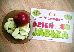 Zdjęcie przedstawia pokrojone jabłka oraz napis przygotowany z okazji tego dnia.
