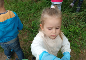 dziewczynka wrzuca śmiecia do worka na odpady