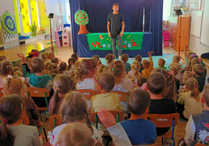 publicznośćuchwycona "od tyłu", w głebi scena i aktor witający się z publicznością