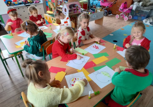 grupa dzieci pozuje do zdjęcia, trzymają tacę z jabłkami