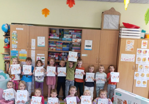 Dzieci z grupy Pszczółki pozują do zdjęcia z pakietami do realizacji prpgramu.