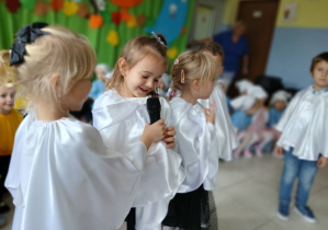grupa dzieci przebranych za duszki prezentuje się w piosence, w tle pozostałe dzieci