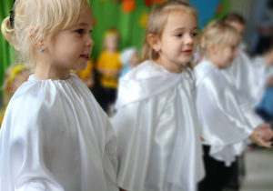 grupa dzieci przebranych za duszki prezentuje się w piosence, w tle pozostałe dzieci