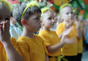 na pierwszym planie grupa dzieci przebranych za pszczółki w tle dzieci z pozostałych