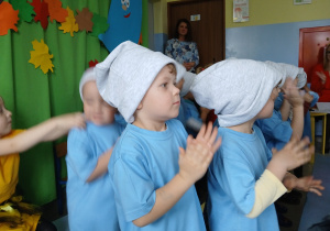 grupa dzieci przebranych za smerfy, prezentują piosenkę rodzicom i klaszczą