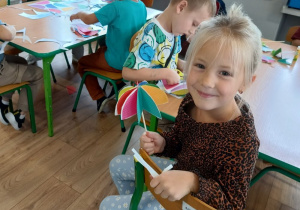 dziewczynka prezentuje gotową parasolkę wykonaną przez siebie, w tle pozostałe dzieci