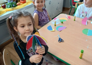 dziewczynka prezentuje gotową parasolkę wykonaną przez siebie, w tle pozostałe dzieci