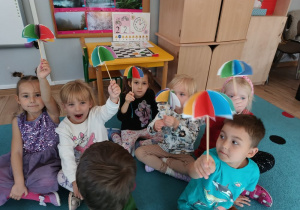 grupa dzieci przentuje wykonane przez siebie kolorowe parasolki