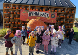 grupa dzieci pozuje do zdjęcia na tle dekoracji z dyniami