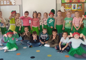 grupa dzieci przebranych za elfy, mają zielone ubrania, czapki elfów na głowach , pozują do zdjęcia