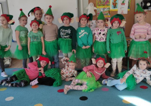 grupa dzieci przebranych za elfy, mają zielone ubrania, czapki elfów na głowach , pozują do zdjęcia