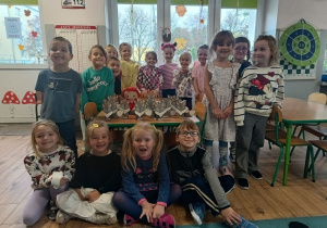 grupa dzieci w klasie, na stoliczku leżą wykonane z kartonu wilki