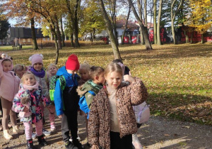 grupa dzieci wędruje alejkamiw parku miejskim