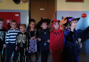 Dzieci stoją w kole podczas balu. Wszyscy przebrani są w tematyczne stroje.