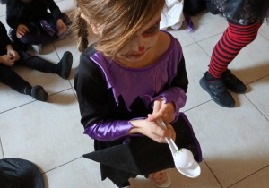 Dziewczynka przenosi jajko na łyżce.