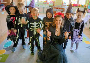 Nauczycielka wraz z dziećmi pozuje do zdjęcia. Wszyscy mają na sobie tematyczne stroje.