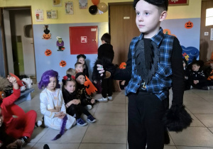 Chłopiec przebrany za wilka rozmawia z prowadzącą bal. W tle znajdują się pozostałe dzieci.