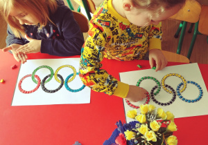 dwóch chłopców wykleja plasteliną symbol olimpijski