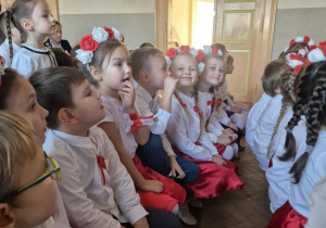 Dzieci w odświętnych strojach siedzą na widowni Młodzieżowego Domu Kultury.