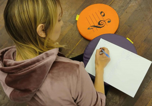 nauczycielka siedzi na podłodze,pisze na kartce