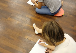 nauczycielki siedzą na podłodze - piszą na kartkach