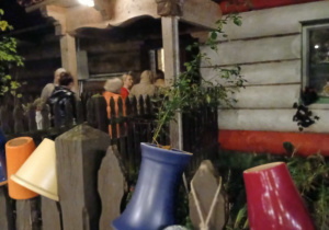 chata Gniazda w Felicjanowie, na pierwszym planie gloniane kolorowe dzbanki powieszone na płocie