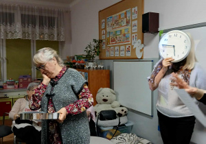 próby do przedstawienia , jedna pani stoi i trzyma sięza głowę, jedna siedzi, a kolejna stoi z zegarem trzymanym na wysokości twarzy