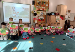 grupa dziei pozuje do zdjęcia z pracami wykonanymi na zajęciach - jest to mapa Polski