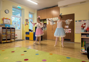 dwie artystki baletowe w scenicznych sukienkach tańczą dla przedszkolaków