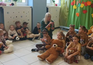 grupa dzieci w szatni, w rękach mają misie, obok nich pani dyrektor