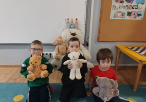 trzech chłopców w klasie, trzymają w rękach pluszaki , pozują do zdjęcia
