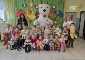 grupa Duszki i panie pozują do wspólnego zdjęcia z duzym białym misiem