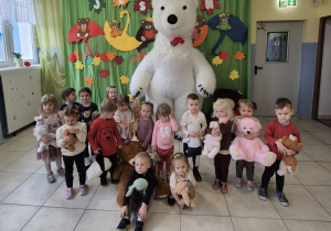 dzieci z grupy Smerfy pozują do wspólnego zdjęcia z duzym białym misiem