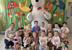 dzieci z grupy Biedronki oraz nauczycielki pozują do wspólnego zdjęcia z duzym białym misiem