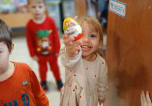 uśmiechnięta dziewczynka pokazuje niespodziankę, którą odnalazła w swoim bucie