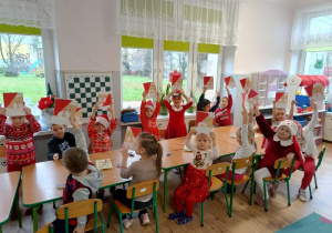 grupa dzieci unosi wykonane przez siebie prace i pozuje do zdjęcia