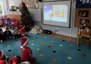 dzieci oglądaja na tablicy film o historii św. Mikołaja