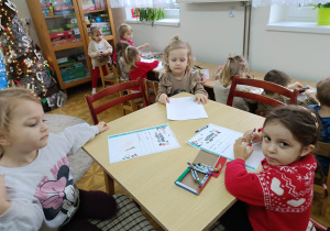 dzieci przy stolikach, rysują prezenty na liście do Mikołaja