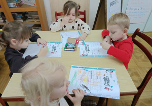 dzieci przy stolikach, rysują prezenty na liście do Mikołaja