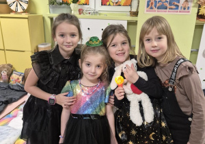 Grupa dziewczynek pozuje do zdjęcia. W tle znajdują się śpiwory.