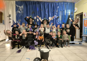 Dzieci wraz z nauczycielkami pozują do zdjęcia. Wszyscy robią śmieszna miny.