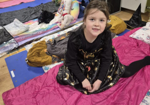 Dziewczynka przebrana za czarownicę pozuje do zdjęcia.