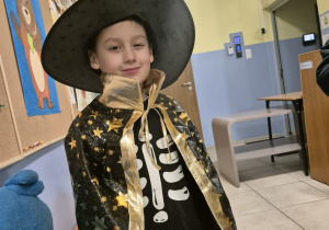 Chłopiec przebrany za czarownika pozuje do zdjęcia.