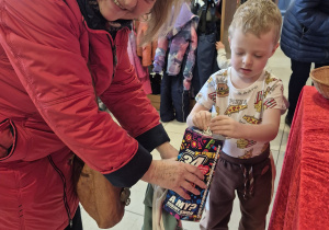 babcia z wnukiem wrzuca pieniądze do puszki